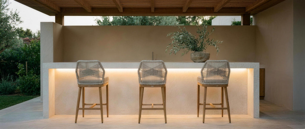 Corda bar stools at a covered travertine outdoor bar with Filo strip lighting at dusk — lifestyle