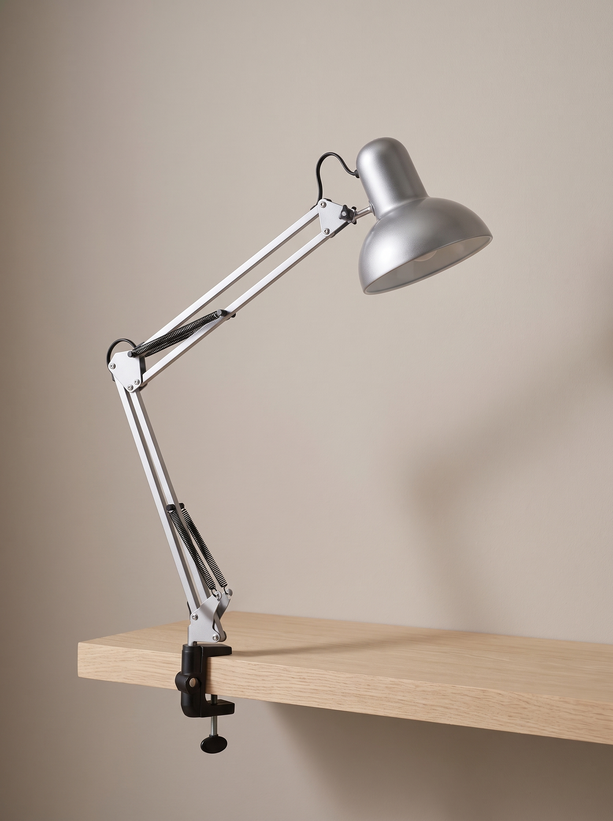 Otis architect clamp lamp in silver on a warm greige backdrop