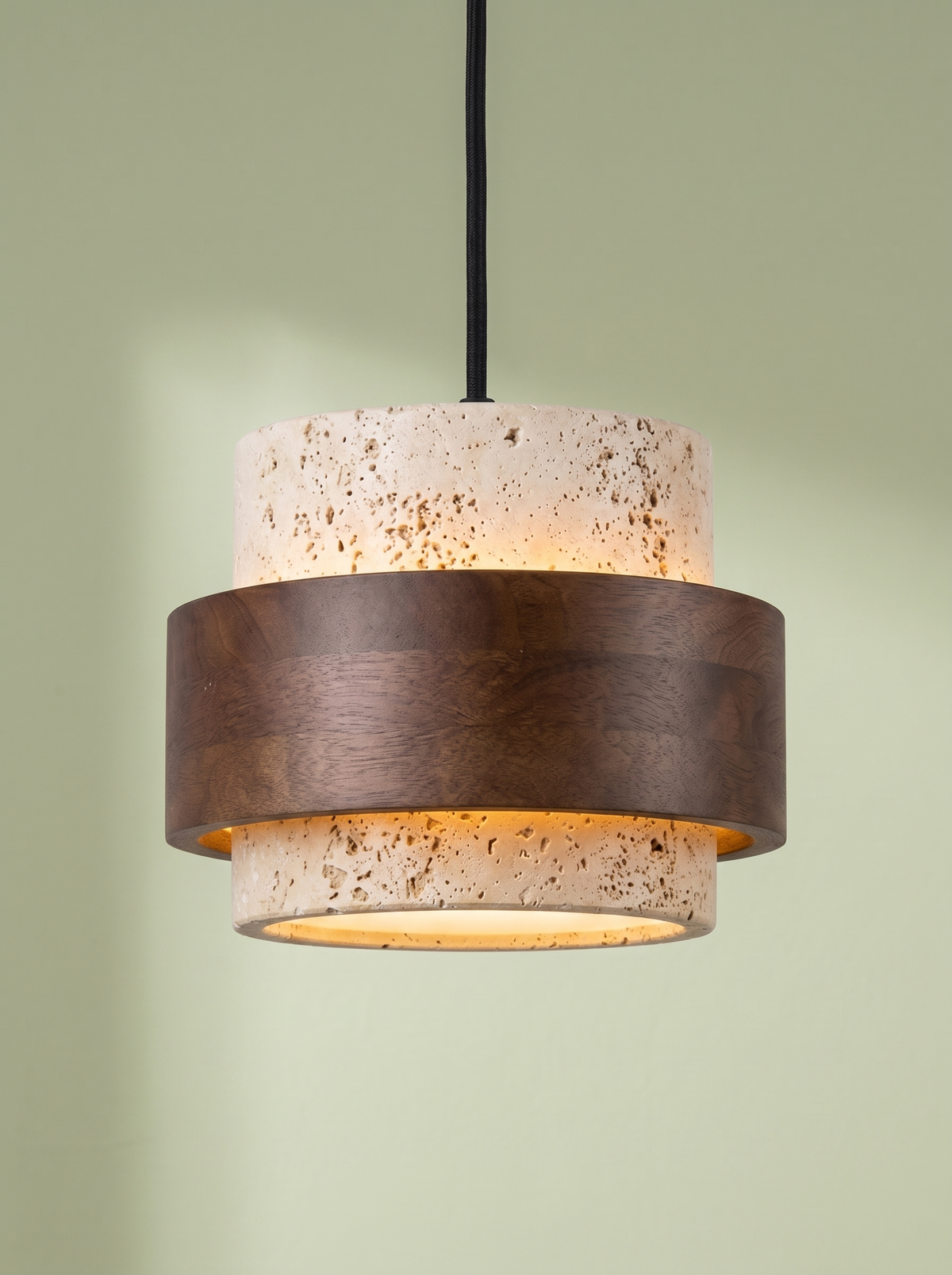 Rune travertine and walnut pendant light glowing on a pistachio green backdrop