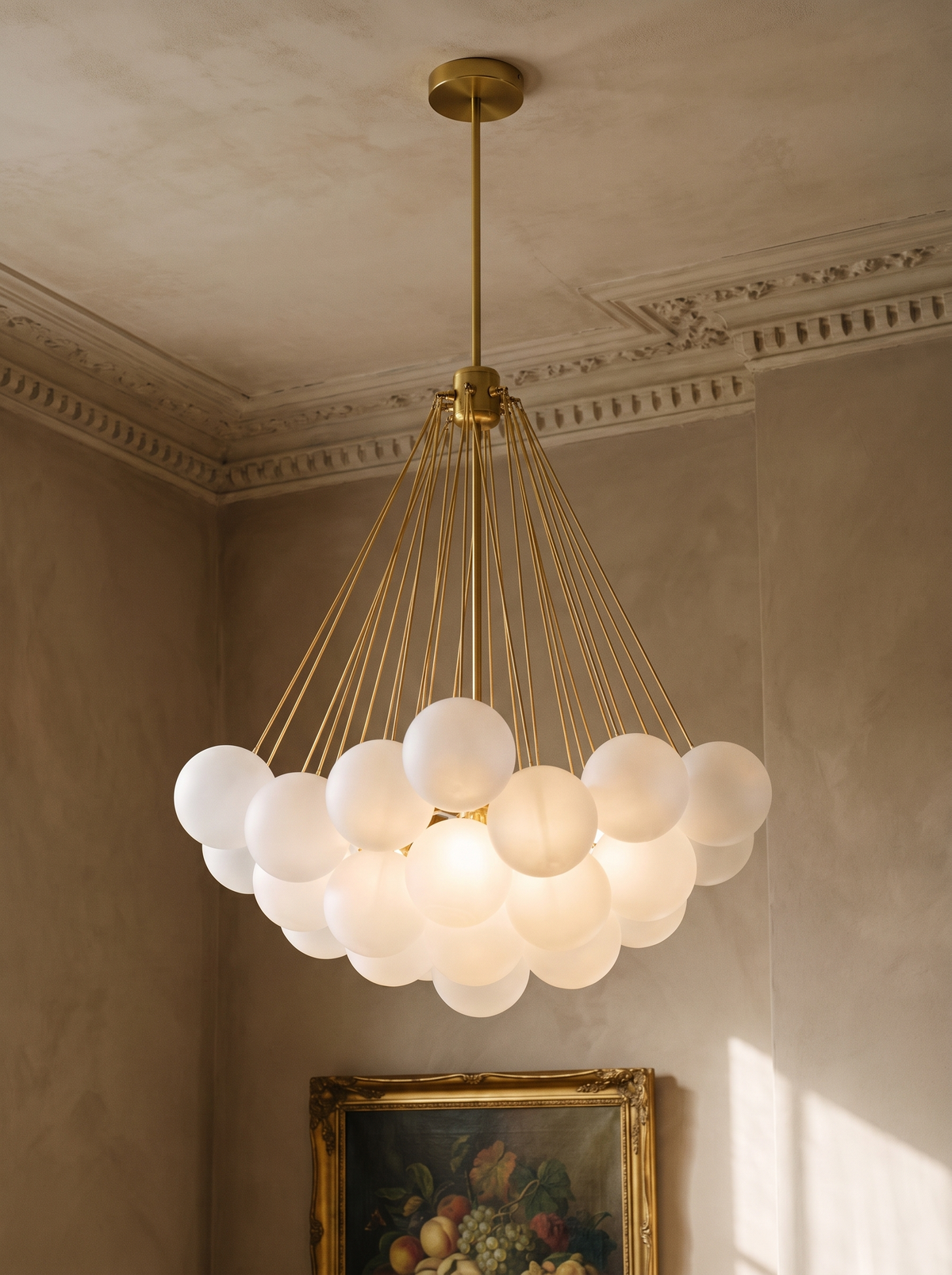 Perle chandelier in gold with frosted glass globes in a plaster-moulded corner