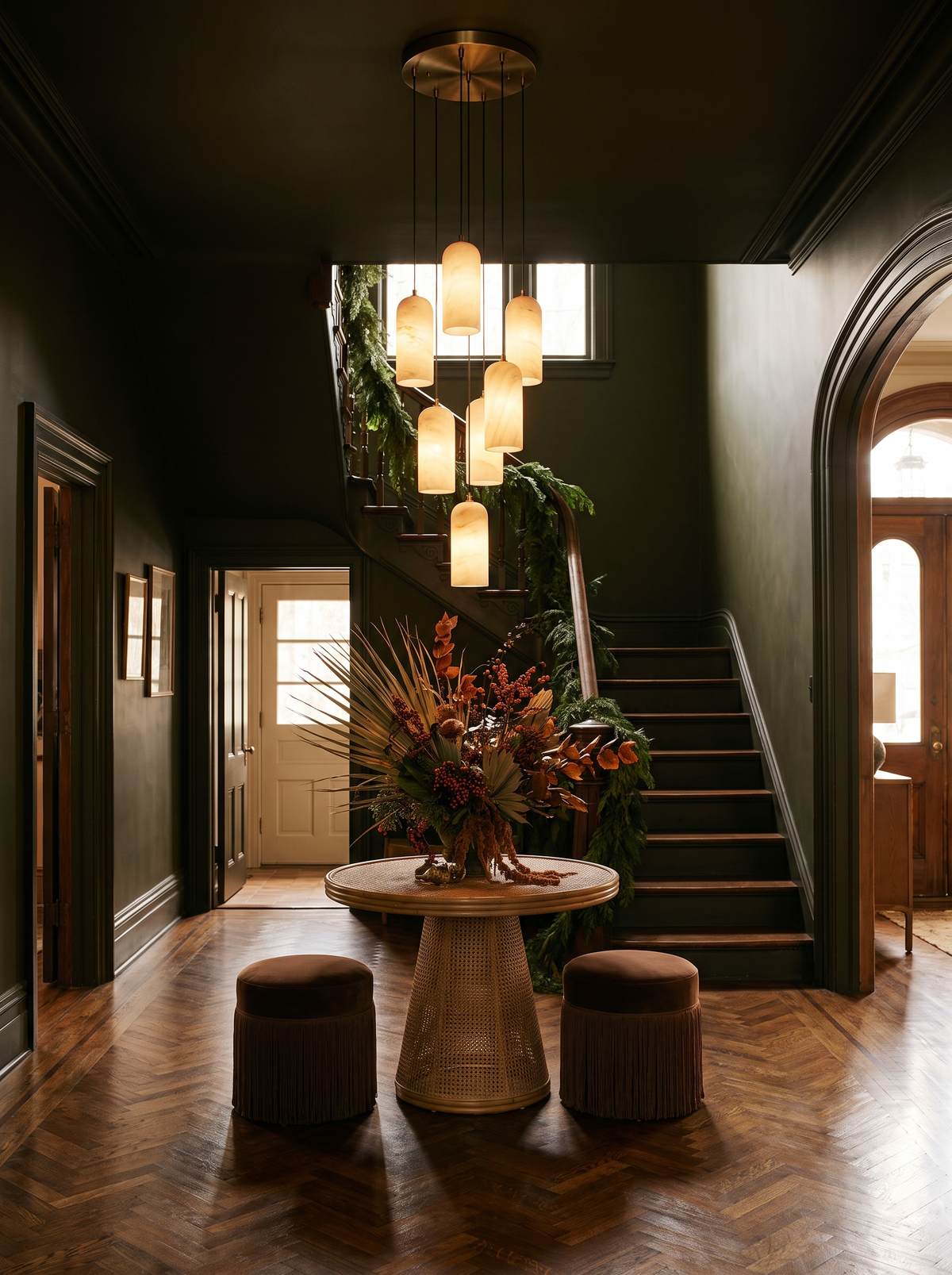 Lifestyle: a seven-pendant Sola alabaster cluster in an olive-black stair hall