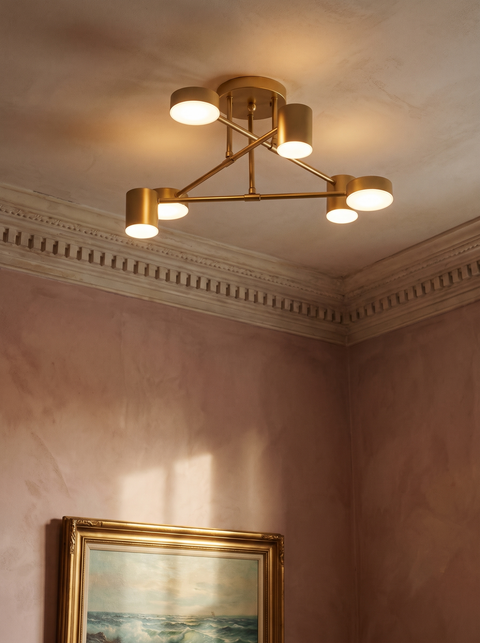 Lys sputnik semi-flush ceiling light in gold in a dusty-rose plaster corner