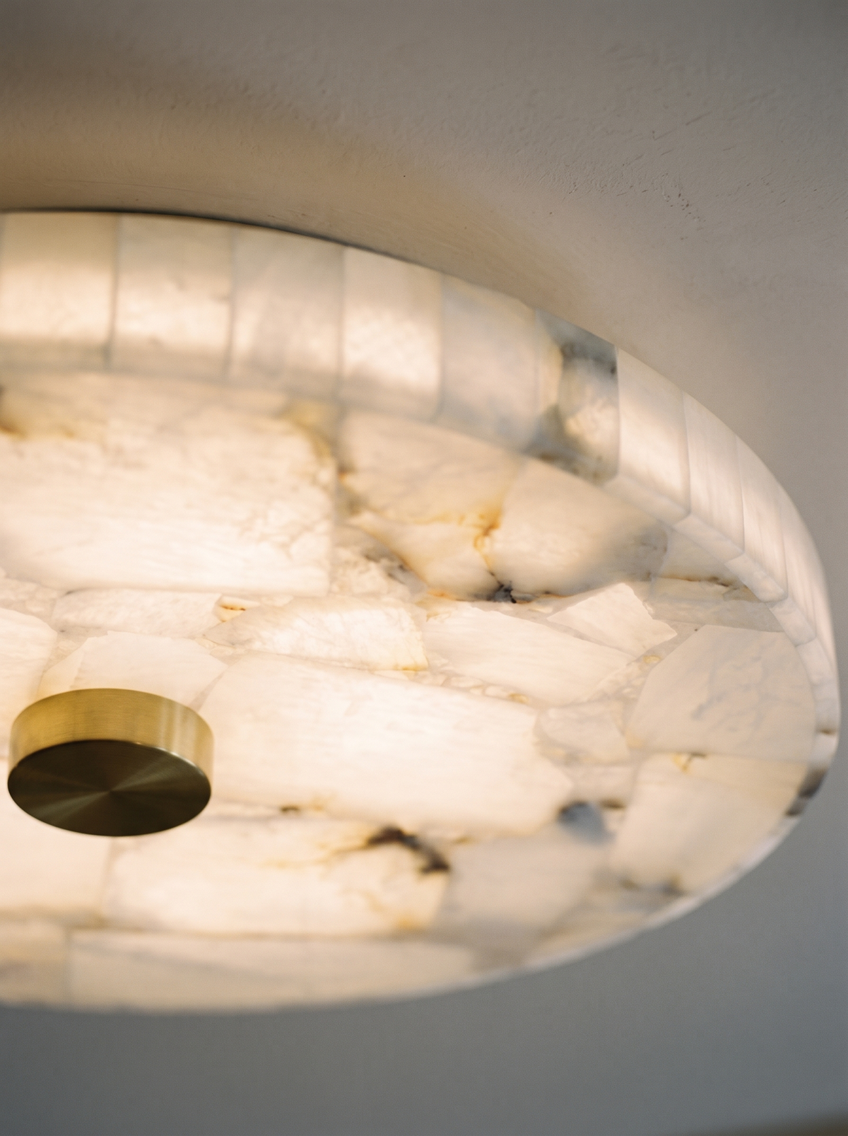 Lifestyle: close-up of Opal's mosaic alabaster and brass centre, lit