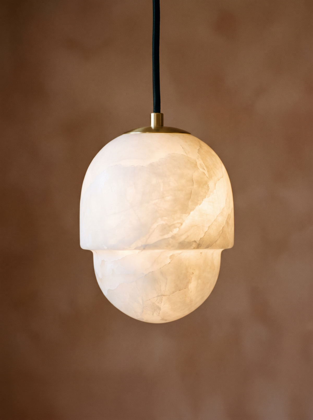 Lifestyle: close-up of Oaklee's acorn-shaped alabaster shade, lit
