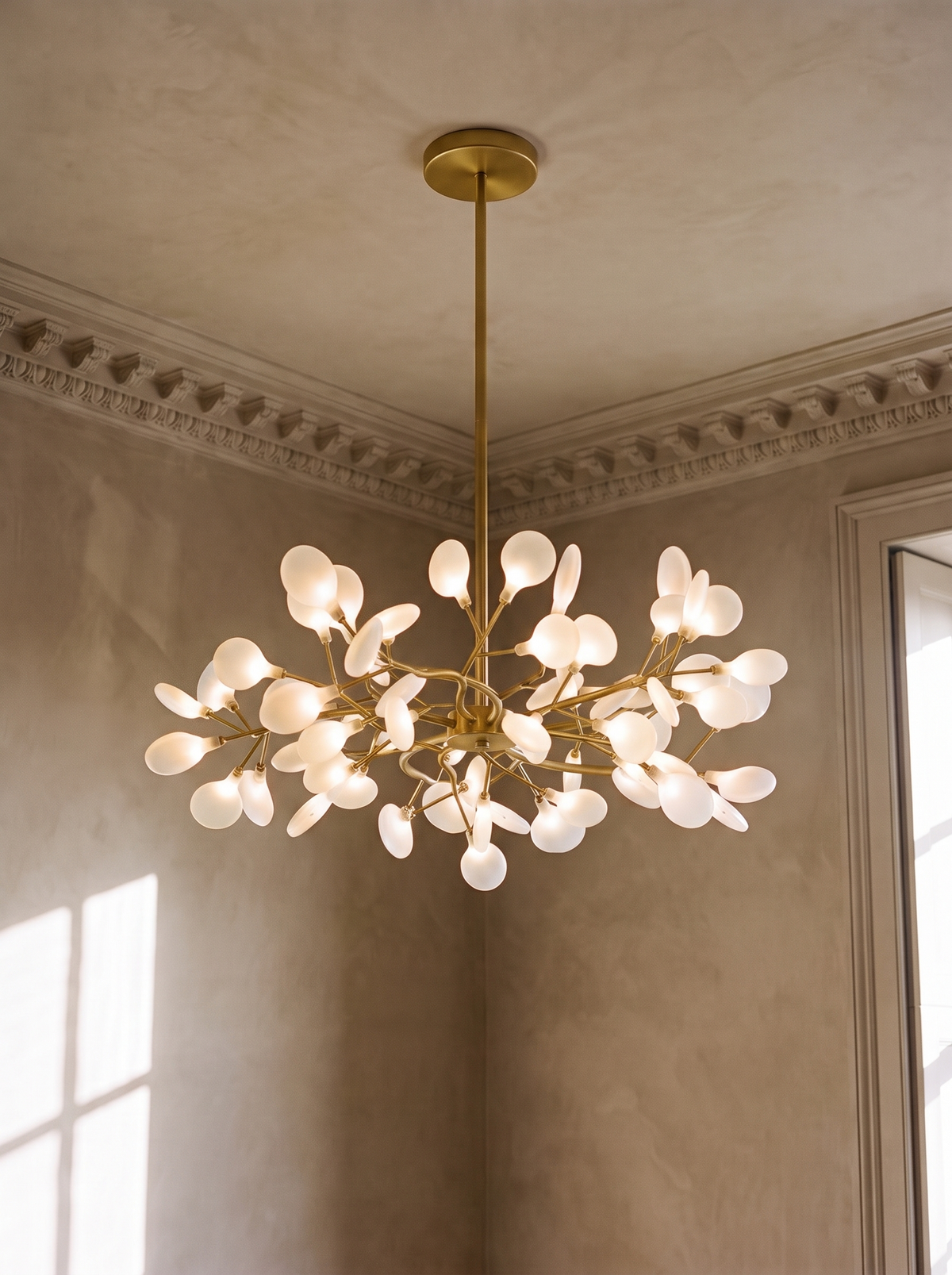 Luce 45-light firefly chandelier in gold hanging in a plaster-moulded corner