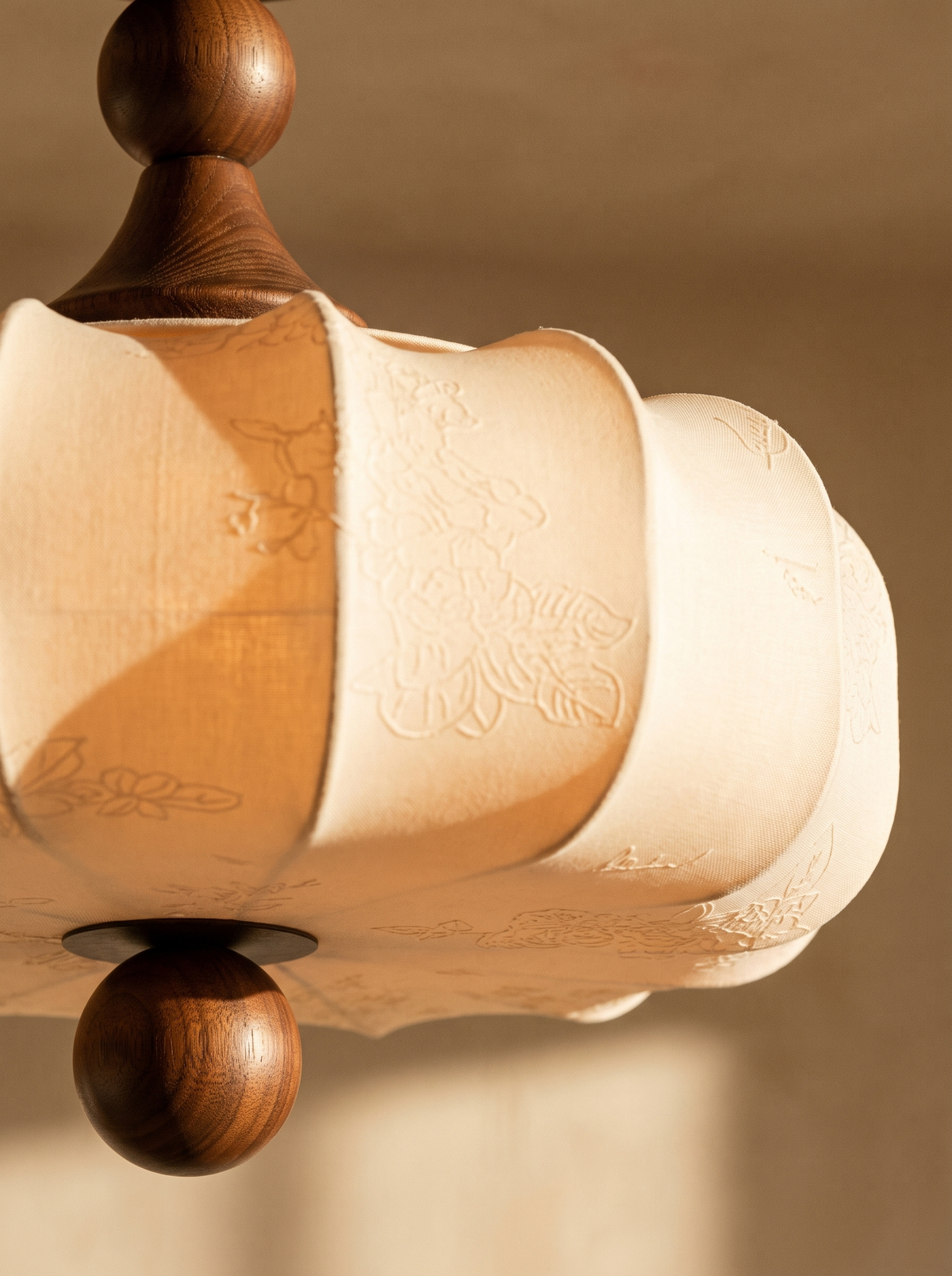 Lifestyle: close-up of Posy's embossed floral fabric and walnut finial, lit