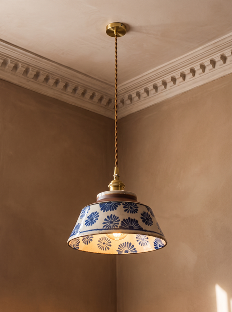 Delft blue daisy ceramic pendant light hanging in a plaster-moulded corner