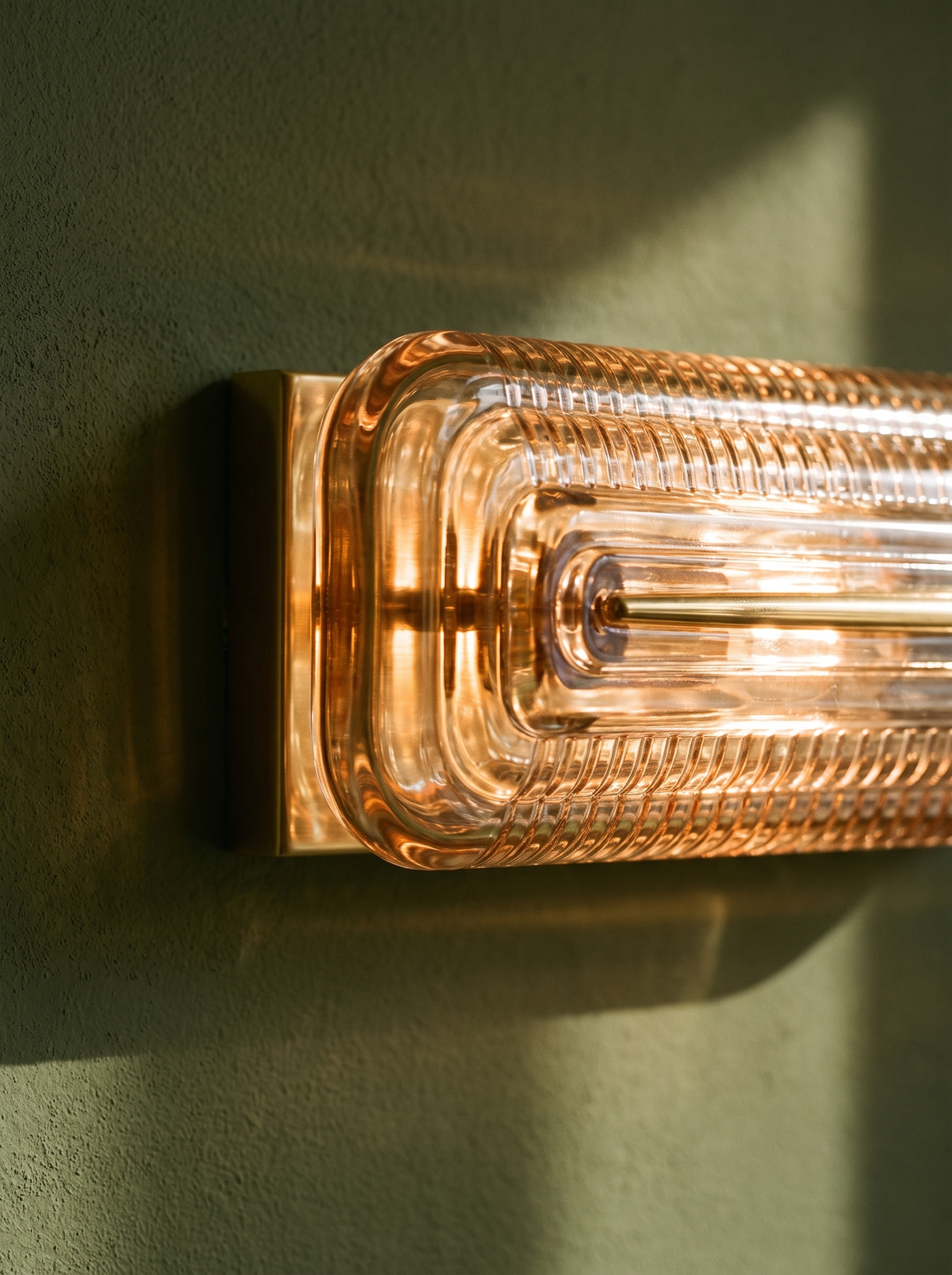 Lifestyle: close-up of Calla's ribbed cognac glass and brass mount, lit