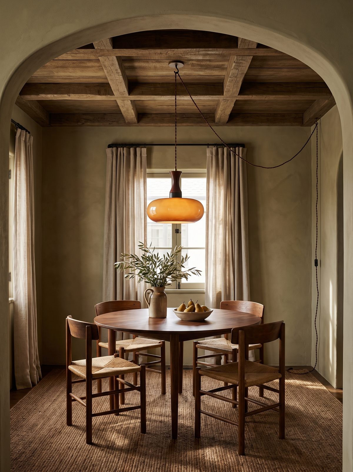 Lifestyle: Toffee caramel glass pendant over a round walnut table in an olive plaster dining room