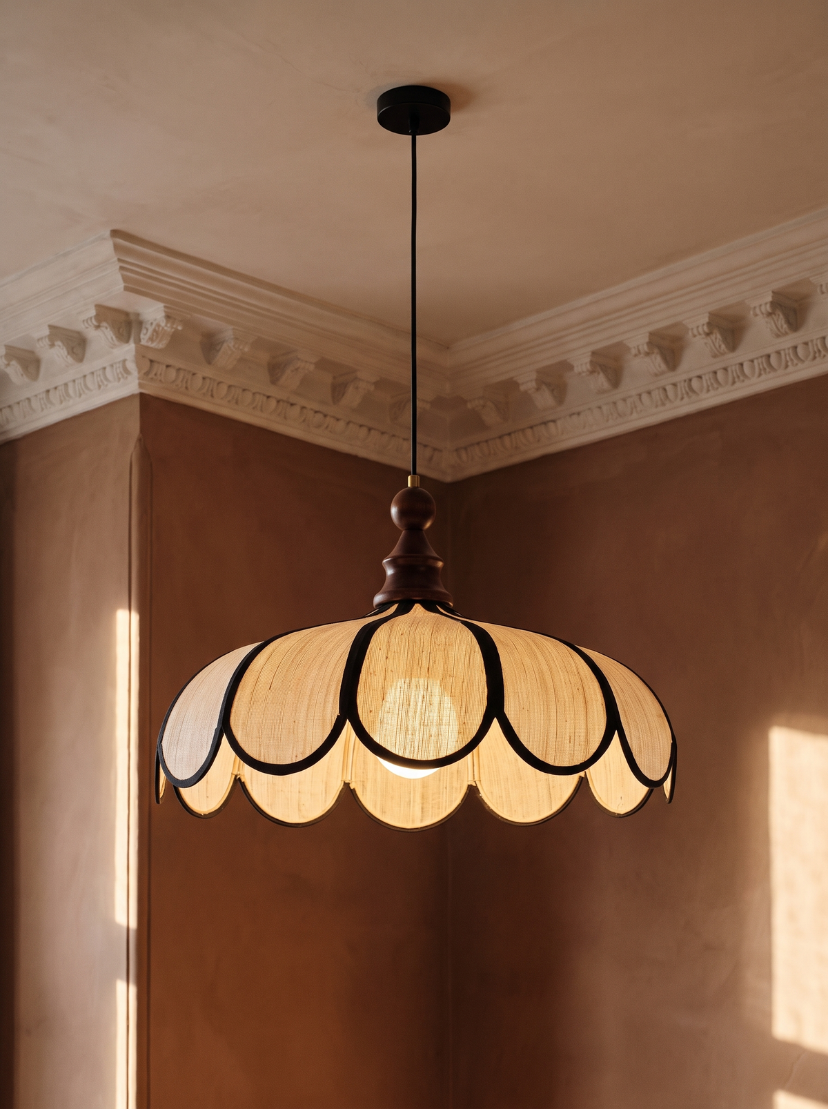 Bluebell scalloped woven pendant light hanging in a plaster-moulded corner
