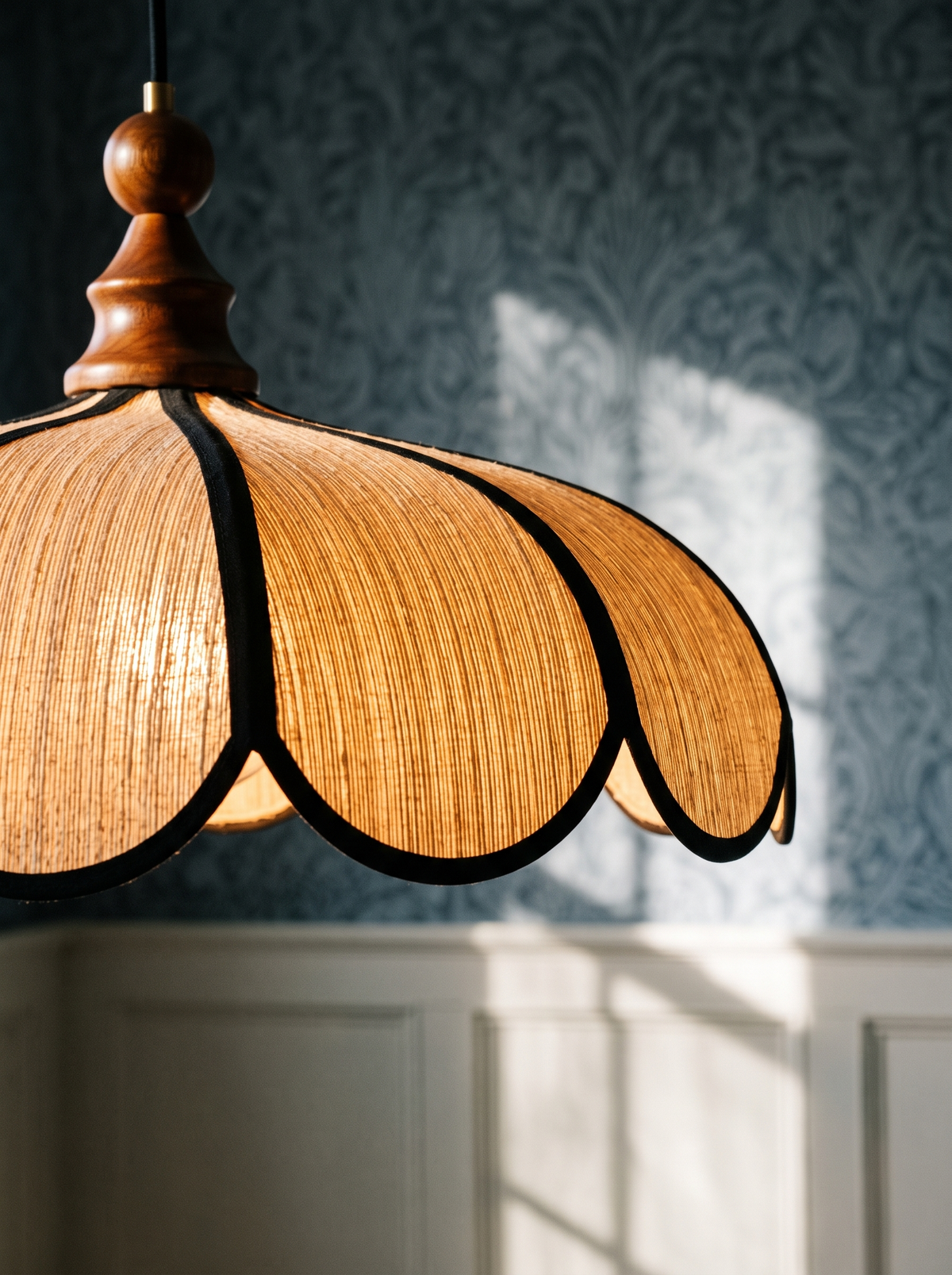 Lifestyle: close-up of Bluebell's hand-woven abaca shade and black-edged scallops, lit