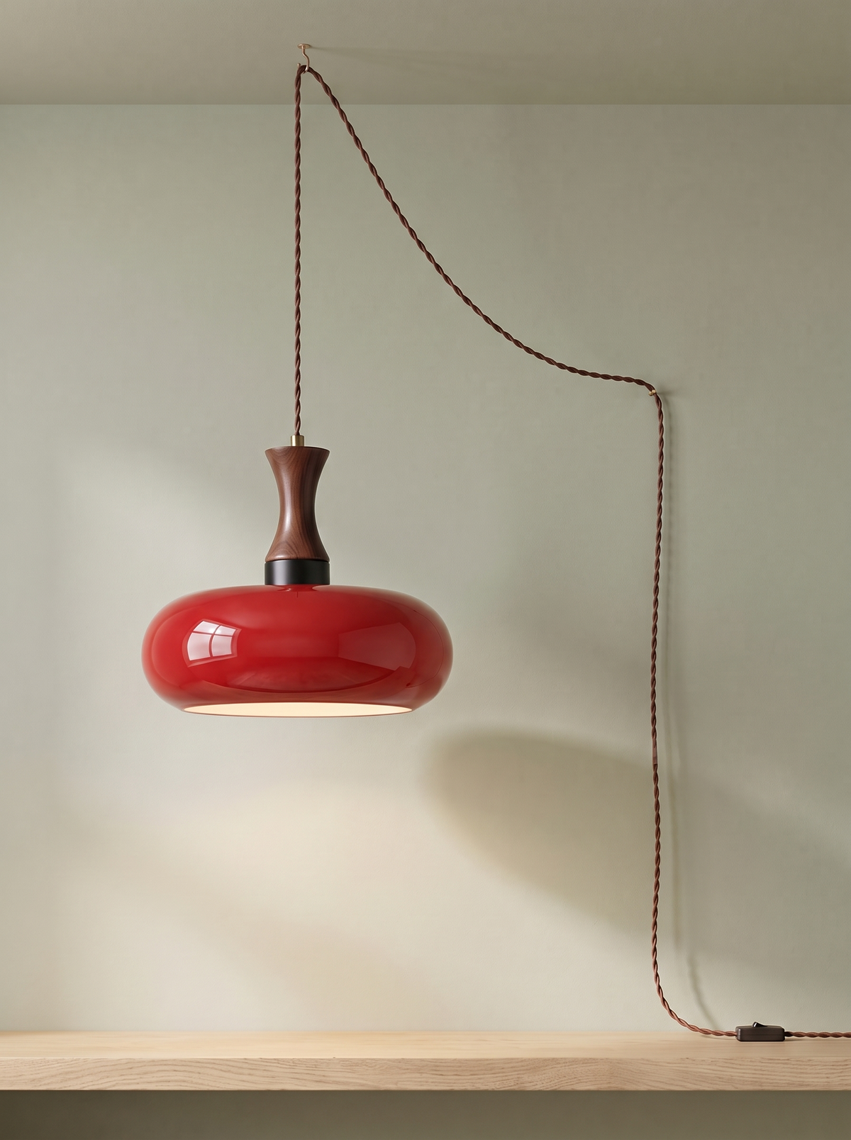 Toffee plug-in glass pendant light in cherry red on a sage green backdrop