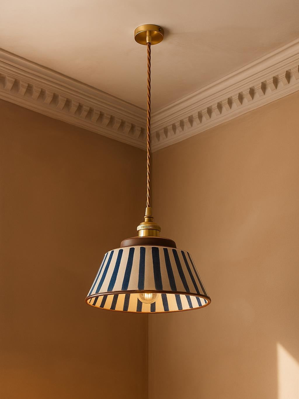 Delft blue stripe ceramic pendant light hanging in a plaster-moulded corner
