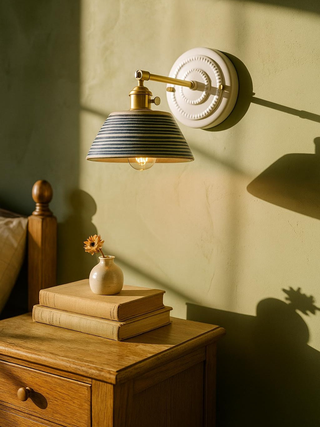 Fable blue ring ceramic wall sconce in brass on a pistachio plaster wall