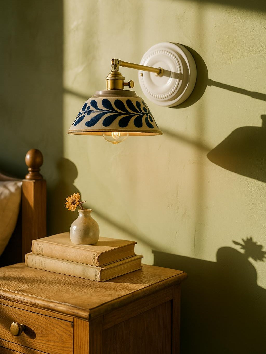 Fable blue vine ceramic wall sconce in brass on a pistachio plaster wall