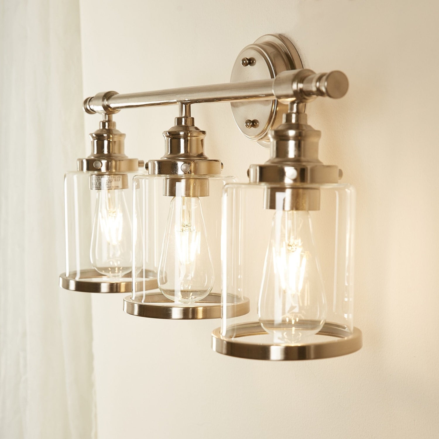 Greer vanity light glowing warm, angled view