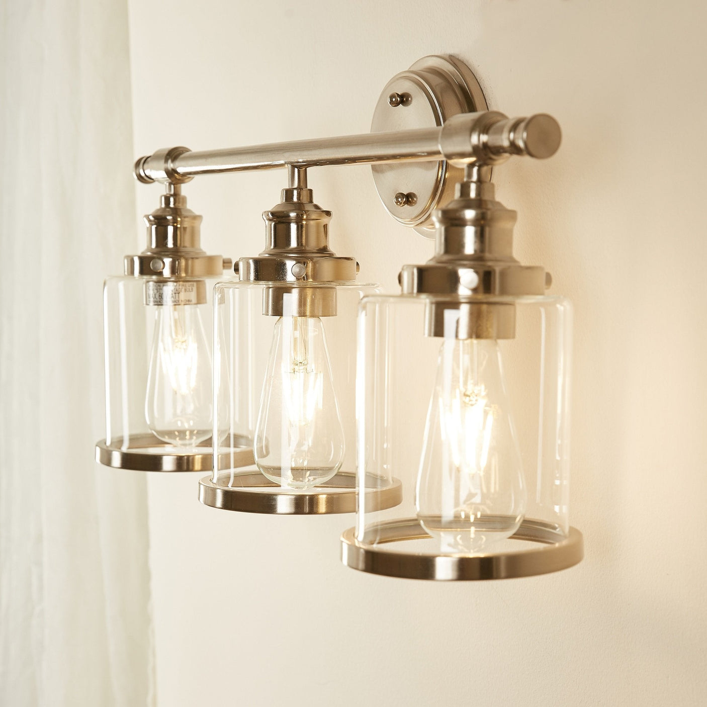 Greer vanity light glowing warm, angled view