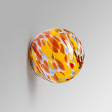 Oria pastel glass wall sconce in colorful on a plaster wall