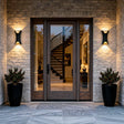 Faro sconces flanking a formal stone entry at dusk — lifestyle