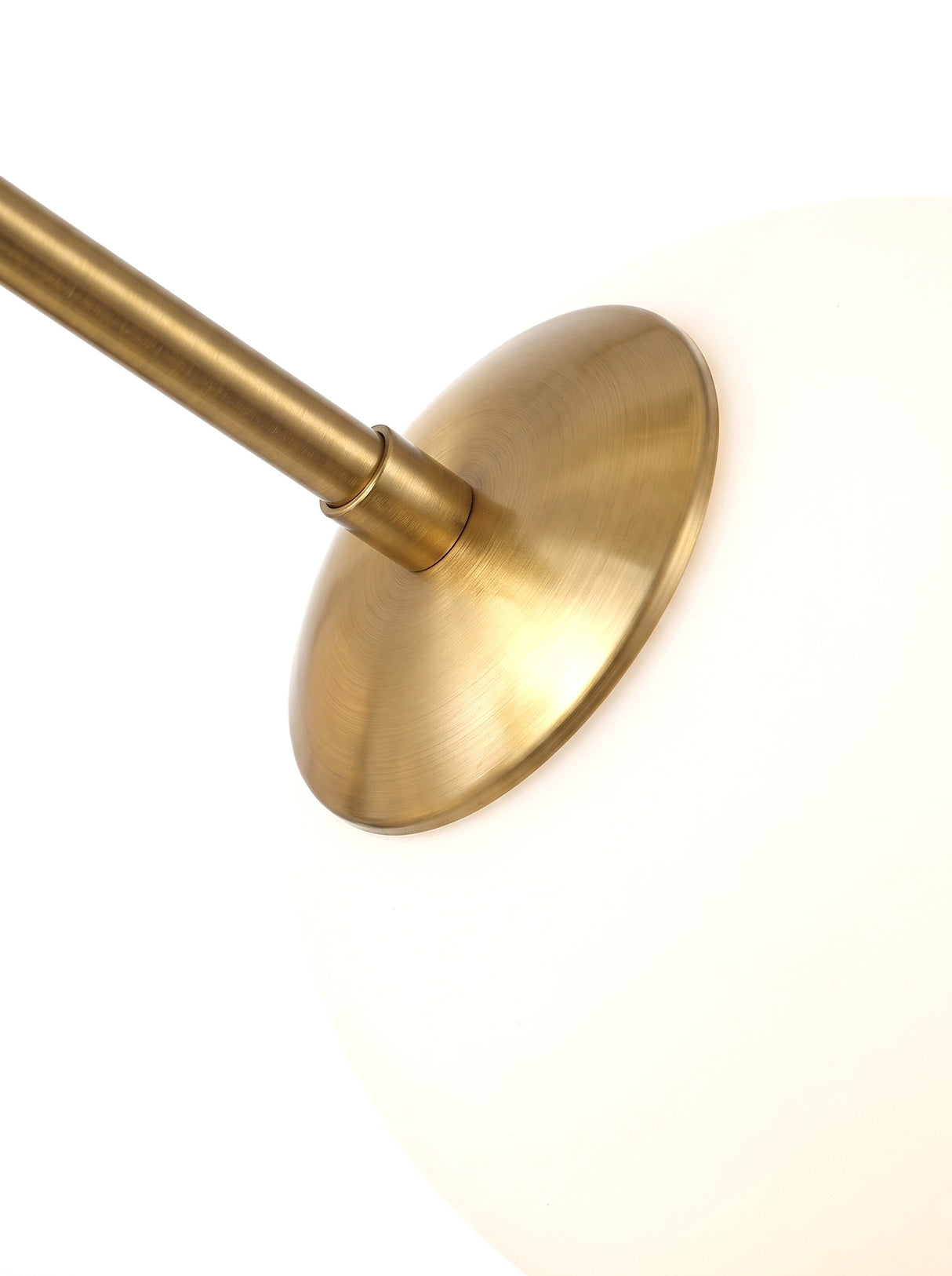 Astra brass socket cradling an opal globe, close-up on white