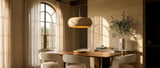 Anello travertine donut pendant over a walnut table in a luxurious travertine dining room — lifestyle