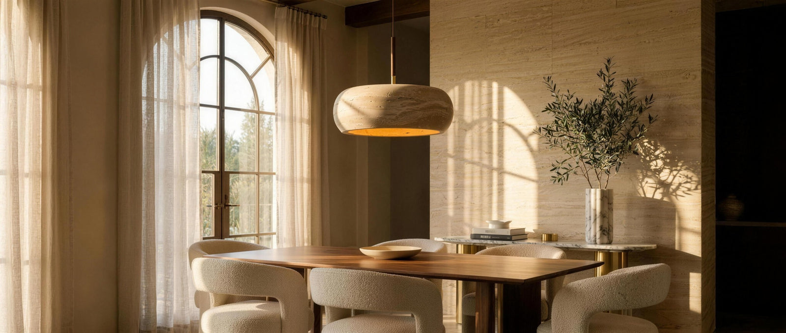 Anello travertine donut pendant over a walnut table in a luxurious travertine dining room — lifestyle