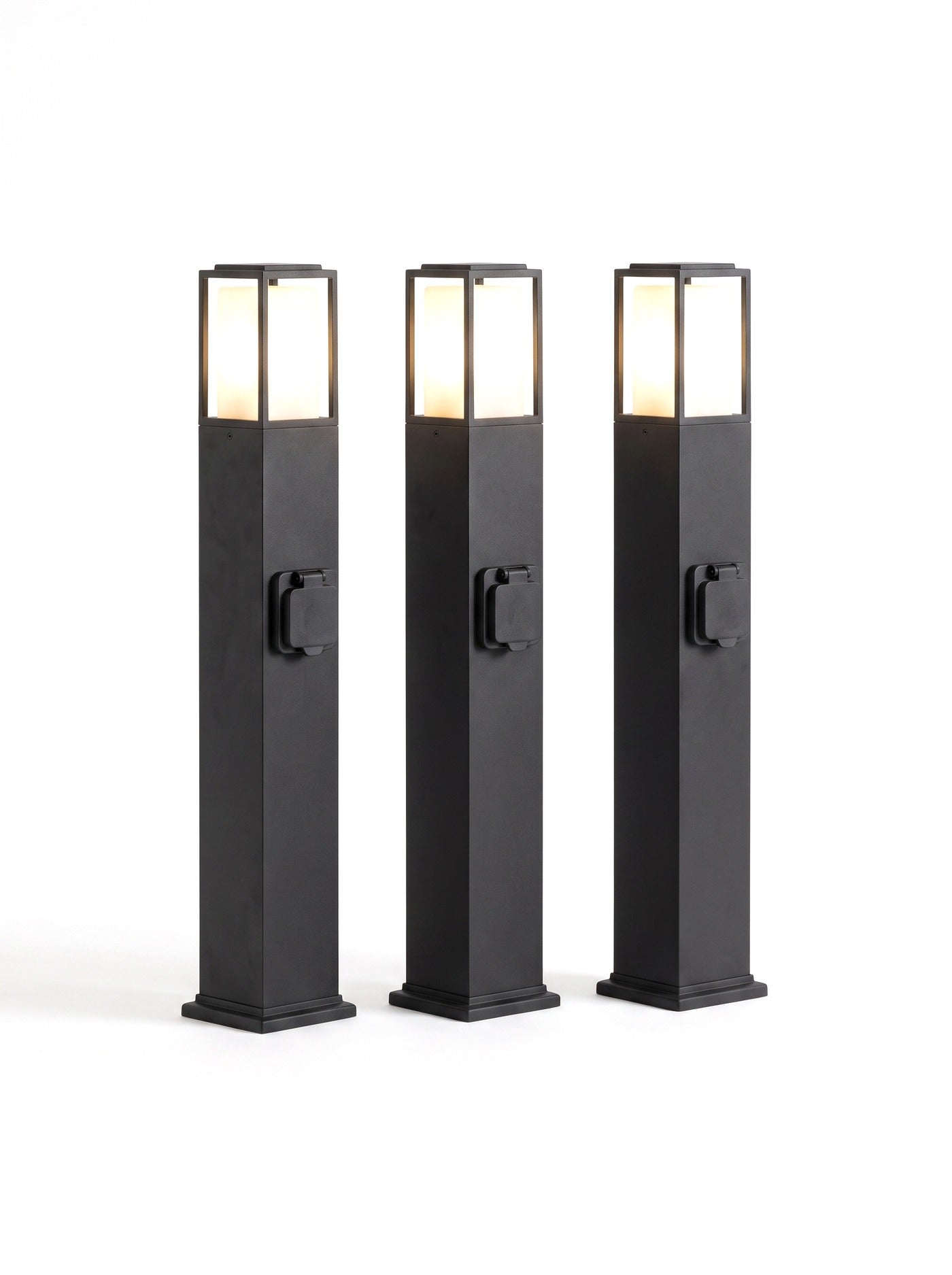 A set of three Cairn bollard path lights on white, heads glowing