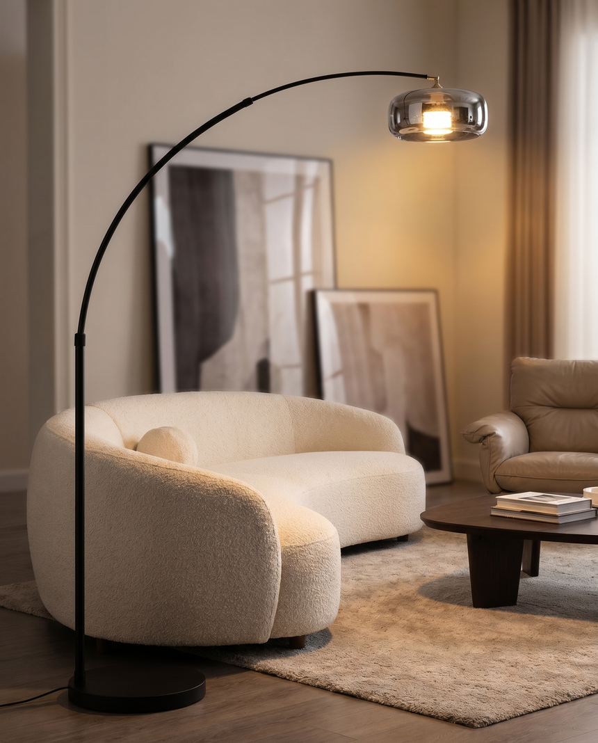Black arc floor lamp with glass shade over sofa, lifestyle