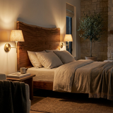 Sconces glowing beside a bed headboard at night