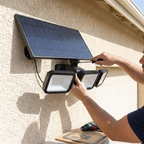 Hands mounting the solar security light on a garage wall