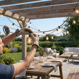 Hands clipping the string lights to a guide wire during install