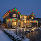 House at night with festive red and green holiday roofline lighting