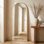 Arched mirror styled in an entryway beside a console table