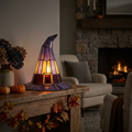 Stained glass witch hat lamp glowing on a mantel with Halloween styling