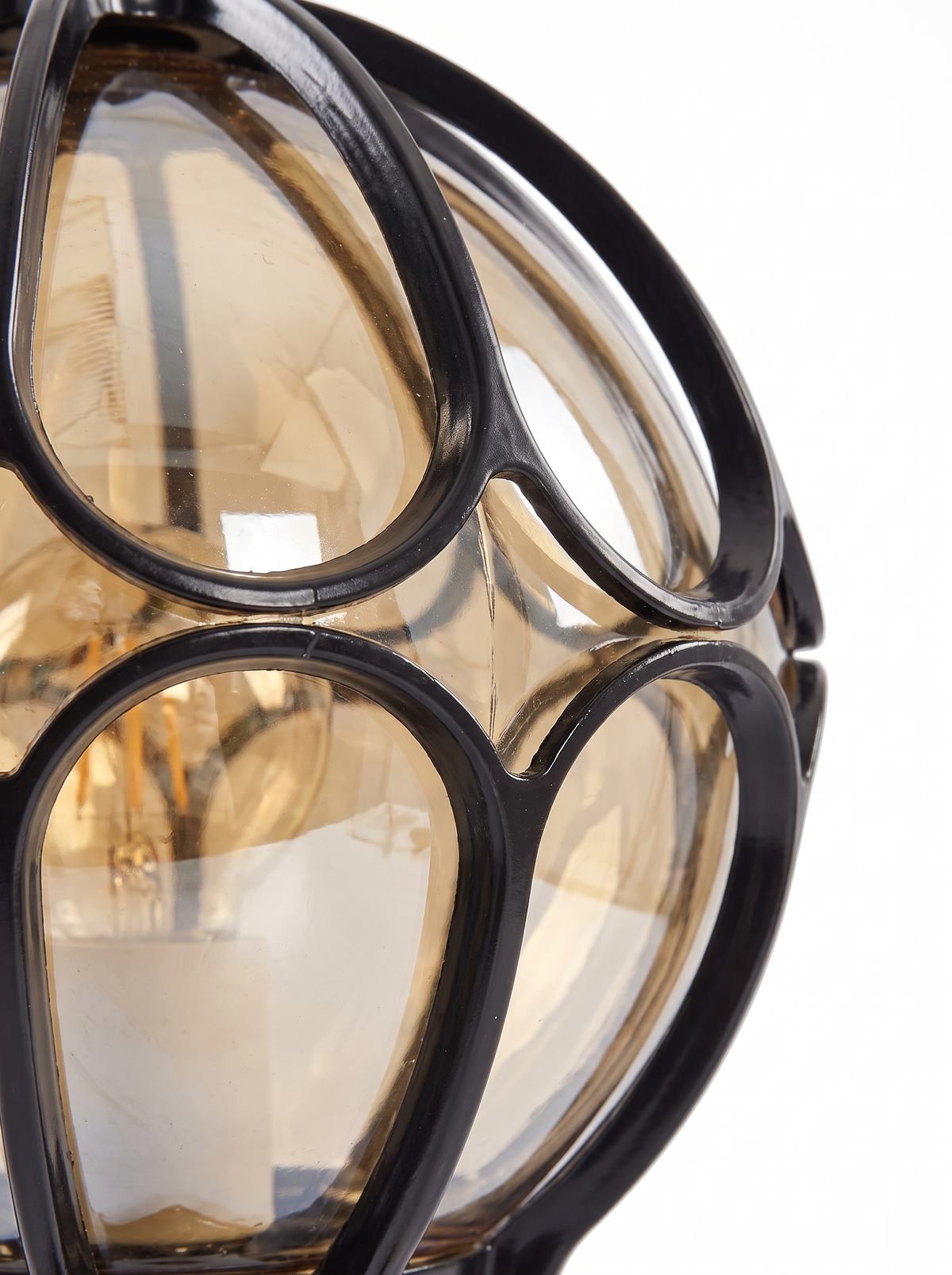 Lune amber glass panels held in the black cast-aluminum cage, close-up on white