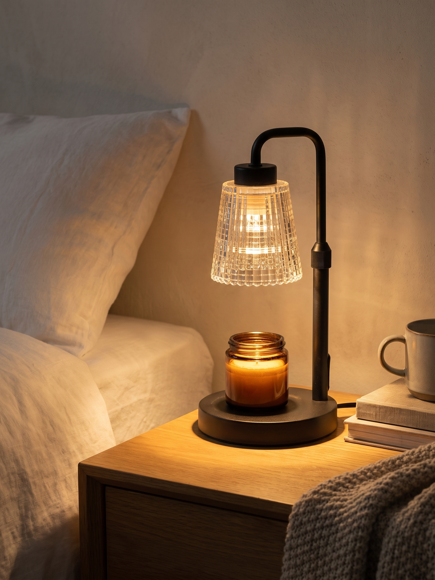 Ember candle warmer lamp glowing on a nightstand at night — lifestyle