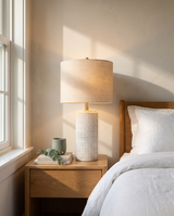 Della ceramic lamp glowing on a bedroom nightstand — lifestyle