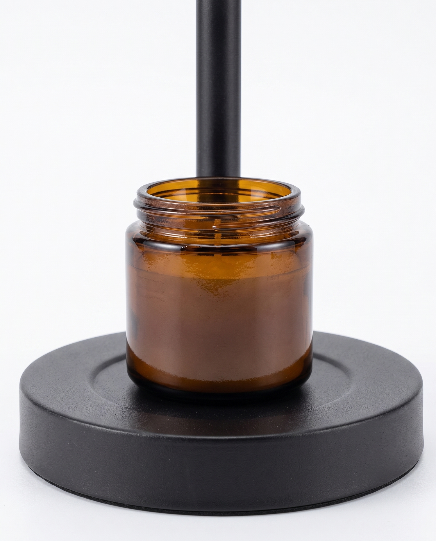 Ember candle warmer base with amber jar candle, close-up on white