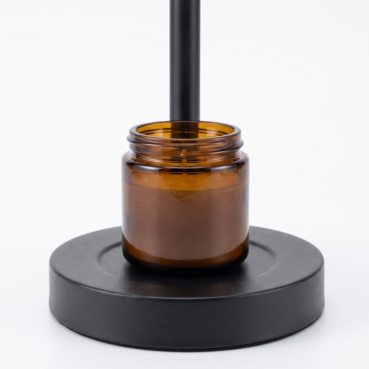 Ember candle warmer base with amber jar candle, close-up on white