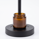 Ember candle warmer base with amber jar candle, close-up on white