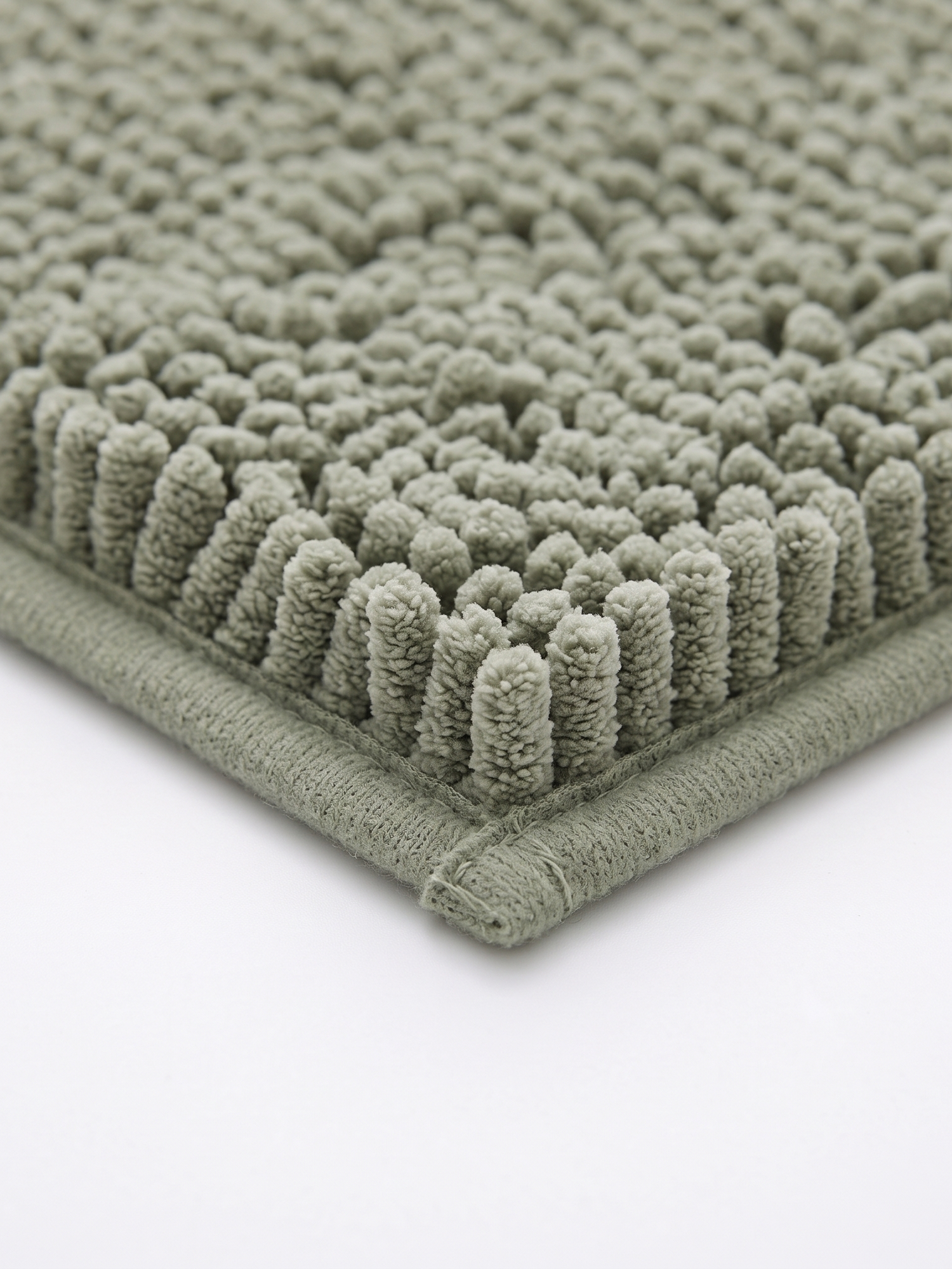 Pebble bath mat bound edge, close-up on white