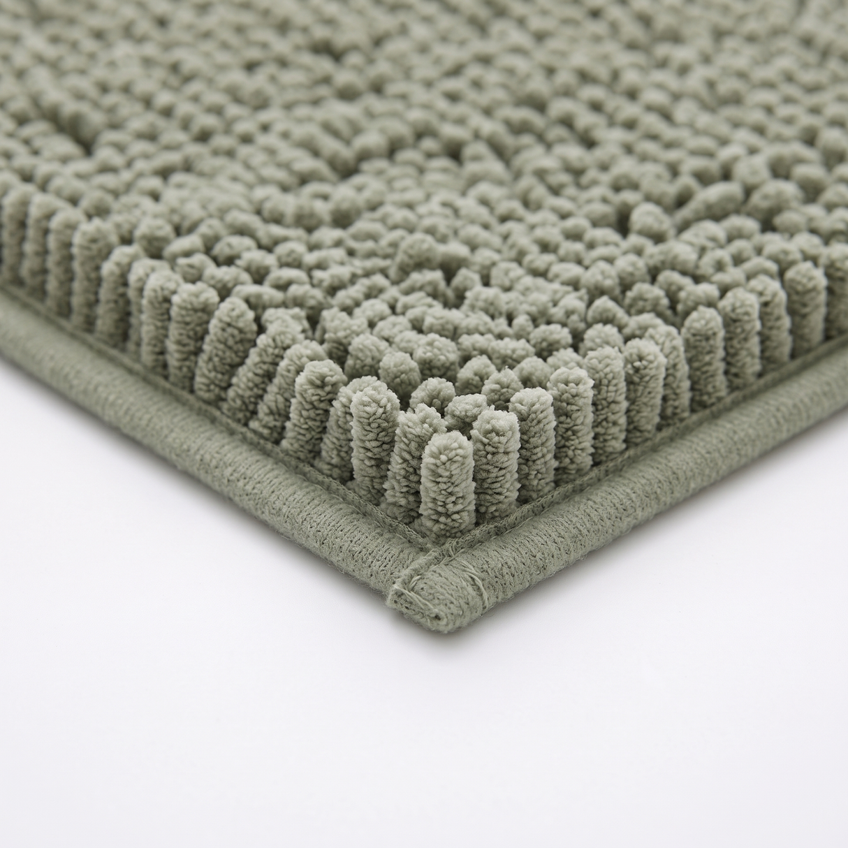 Pebble bath mat bound edge, close-up on white