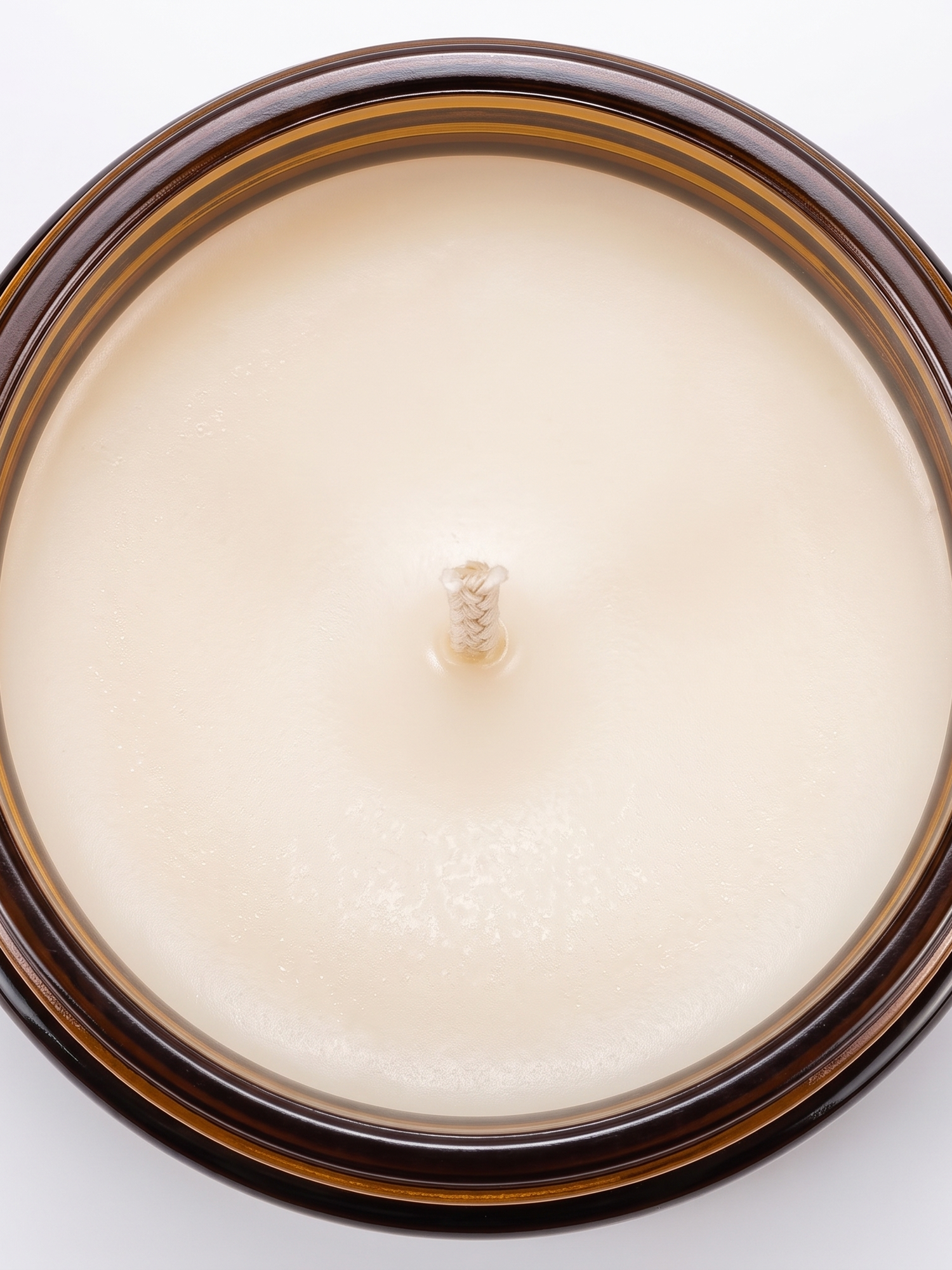 Hearth candle soy wax surface and wick, close-up on white