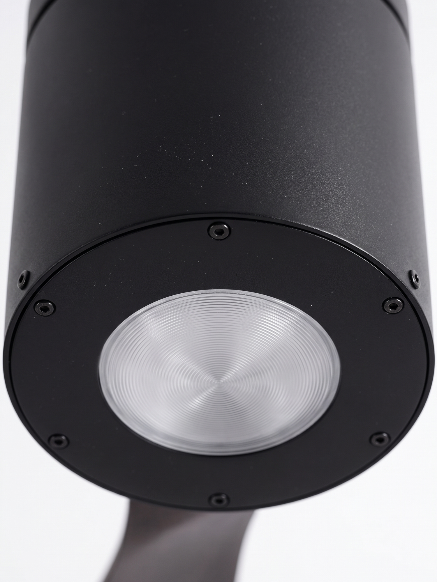 Black DC motor housing with integrated downlight, close-up on white