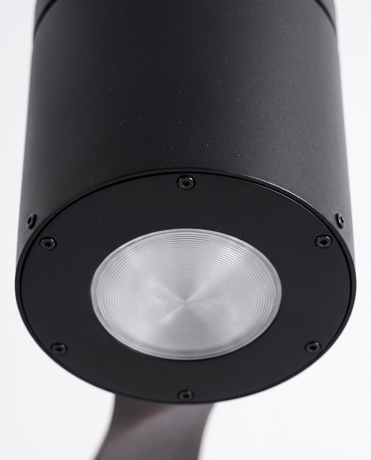 Black DC motor housing with integrated downlight, close-up on white