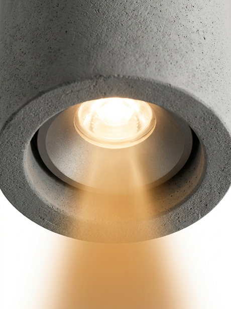 Close-up of the downlight aperture with the LED glowing warm and casting a beam