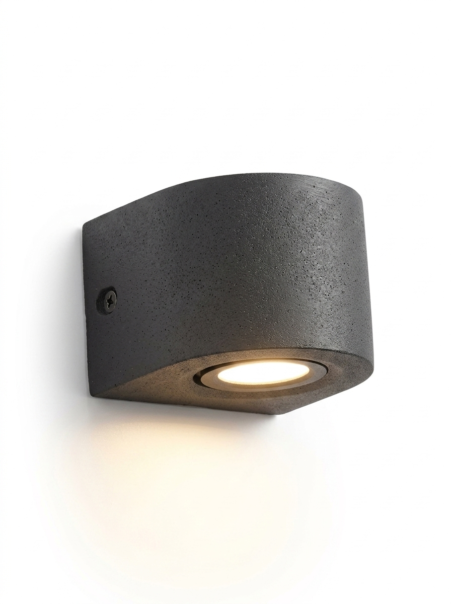 Ilse round curved concrete wall light in gray-black on a studio white background