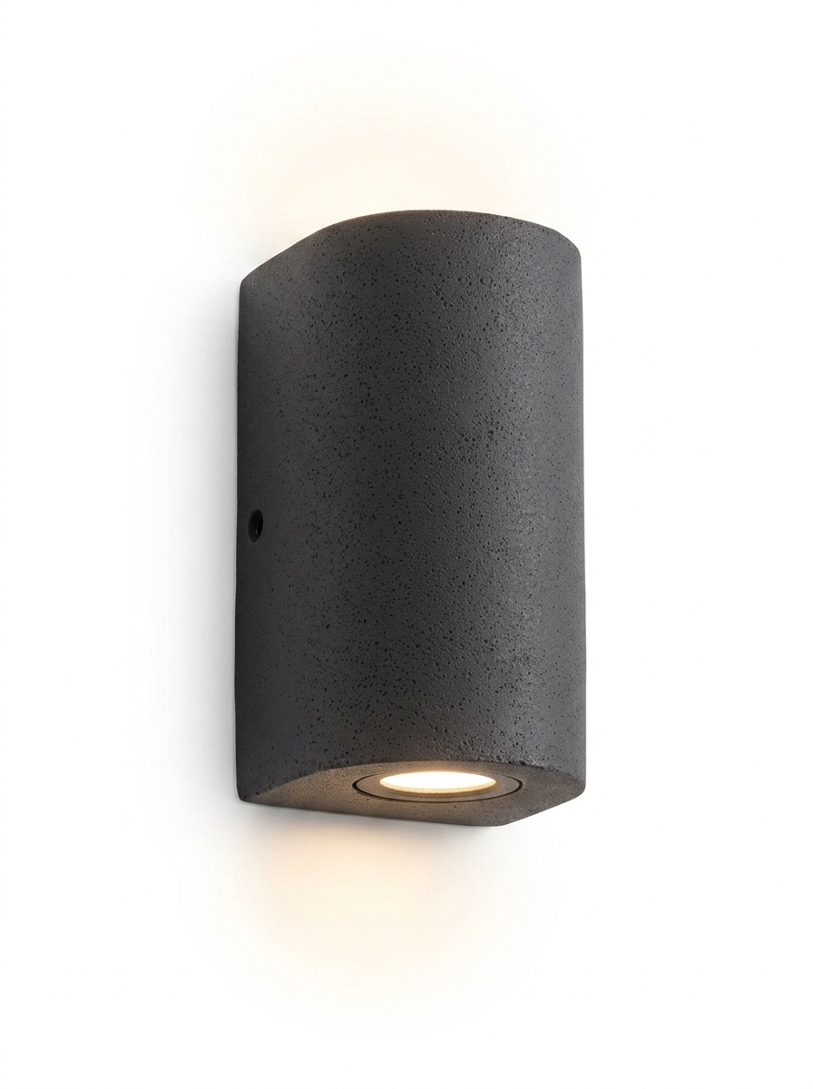 Ilse round tall cylinder concrete up-down wall light in gray-black on a studio white background