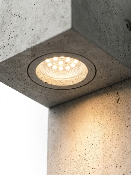 Close-up of the downlight aperture with the LED glowing warm and casting a beam
