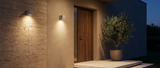 Ilse concrete wall lights on a modern travertine entrance at dusk lifestyle